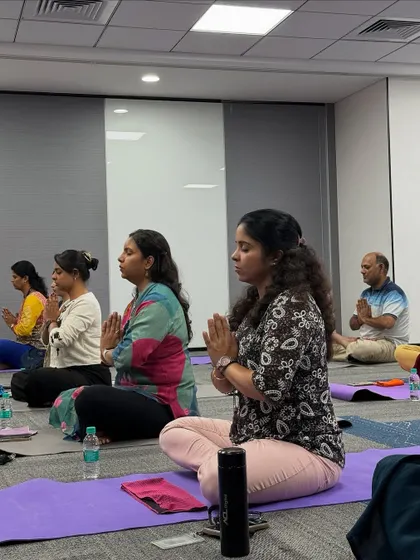 Employees at Manhattan Associates practicing a seated meditation with hands in Anjali Mudra. This simple practice helps center the mind and cultivate a sense of gratitude and peace during the workday.