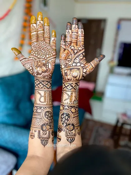 Another view of the personalized bridal mehendi for Rasika, showing how the custom portraits and initials are integrated seamlessly into the traditional design elements like peacocks and paisleys.