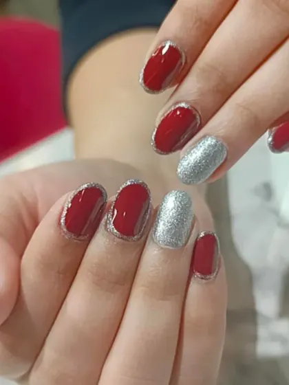 A fun take on a red manicure, with silver glitter outlines and a full-coverage silver glitter accent nail.