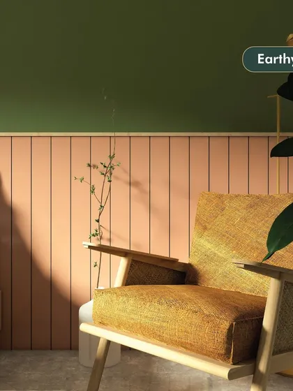 This space showcases an earthy style, with a combination of olive green and terracotta pink wall panels. The natural wood and jute armchair adds to the warm, organic feel of the room.