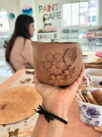 A beautifully detailed, hand-built pottery piece with delicate flower carvings, made by a participant in my workshop.