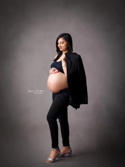 A modern and powerful look. This "boss mama" style with a black blazer and bare bump is for the confident woman who wants to celebrate her strength.
