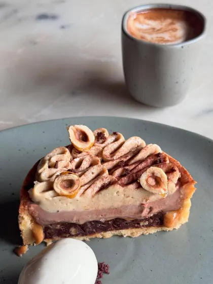 A slice of our Hazelnut Tart, a rich and nutty dessert, paired perfectly with a cup of coffee.