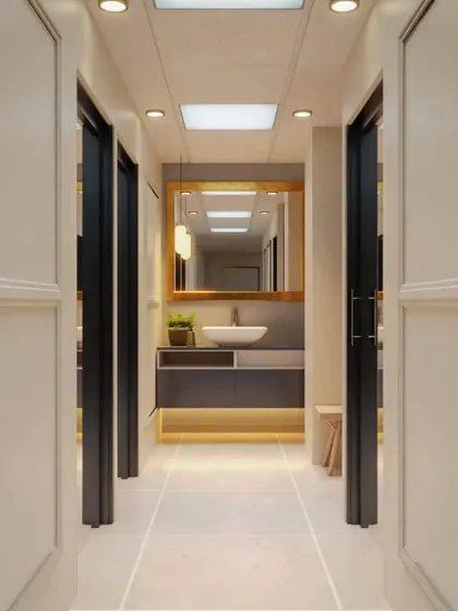A render of a clean and symmetrical hallway leading to a washroom area. We use lighting under the vanity and a large mirror to make the passage feel wider and more inviting.