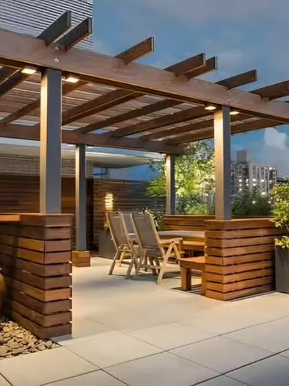 A rooftop terrace design with a wooden pergola providing shade for a comfortable seating and dining area.