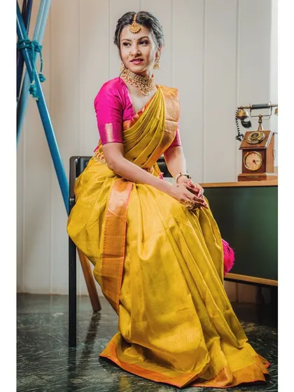 A full-length composition that shows the complete drape of the saree. The vintage props add a touch of nostalgia, ideal for a themed ethnic wear shoot.