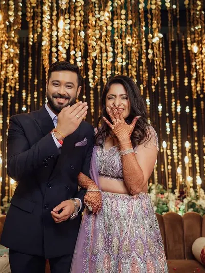 The newly engaged couple happily shows off their rings to the camera, their joyful expressions making for a perfect announcement photo.