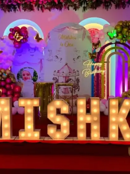 A spectacular carousel and butterfly themed birthday stage with large marquee letters spelling 'MISHKA'.
