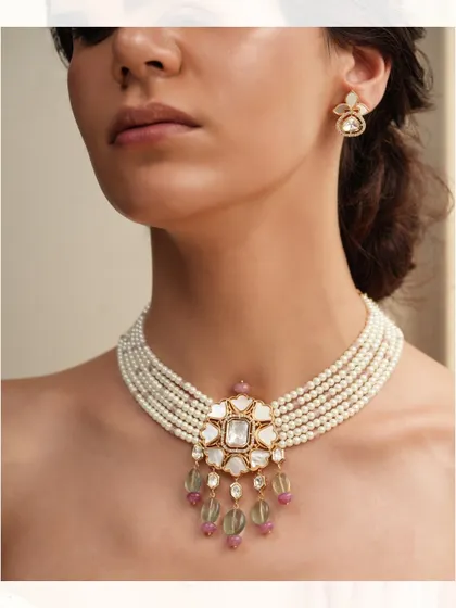 A classic pearl choker with a central polki pendant and delicate colored stone drops.