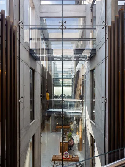 Another perspective of the atrium, showing how the bridges and transparent walls create layers of visual connection between different departments and work zones.