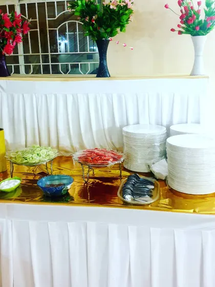 The salad and condiments station, with neatly stacked plates and cutlery. I ensure every part of the meal is well-organized.