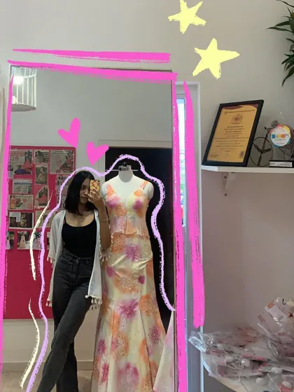 A mirror selfie at a boutique, with a pink frame to make it feel like a piece of art.