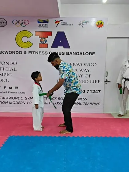 Tying a green belt for a young student.