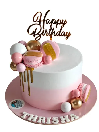 This modern and chic birthday cake features a clean white and pink finish with a stylish gold drip. I decorated it with pink and gold chocolate spheres and matching macarons.