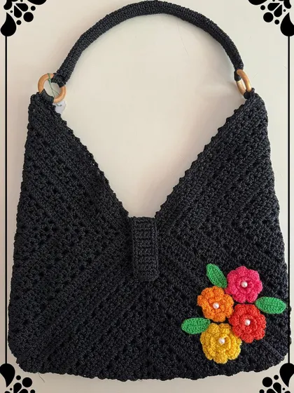 My black beauty bag is a true showstopper. The intricate crochet work is highlighted with bright, handmade flowers, creating a unique piece that will grab everyone’s attention.