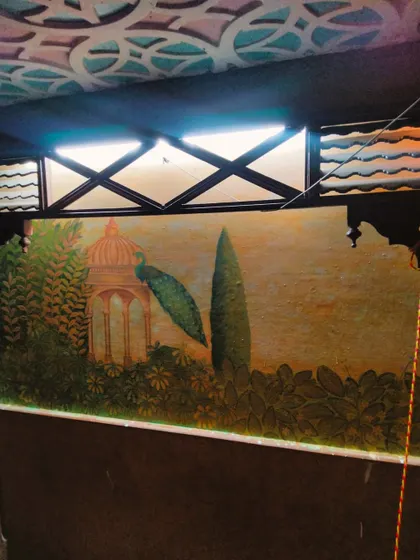 Another section of the Mughal mural, featuring a peacock and a domed pavilion, adding to the regal ambiance of the restaurant.