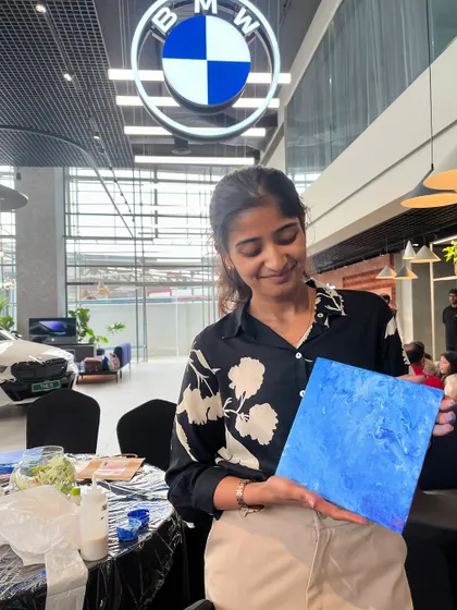 Holding up a finished fluid art piece at the BMW showroom. The colors and design of the cars inspired our art that day.