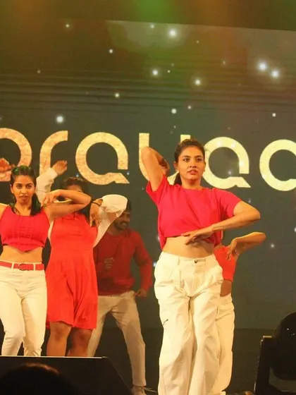 A high-energy moment from our 25th-anniversary event, Prayaan 2023. The stage is filled with dancers in red and white, celebrating a milestone.