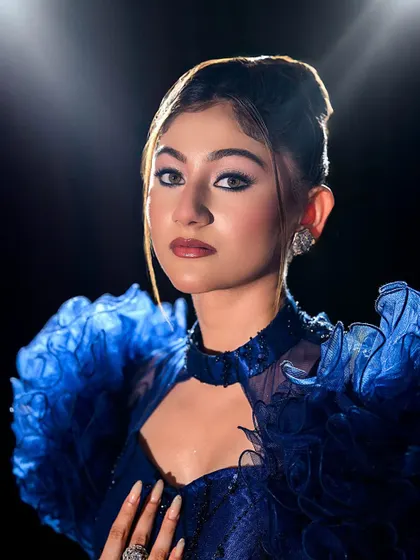 A striking close-up portrait of the blue gown look.
