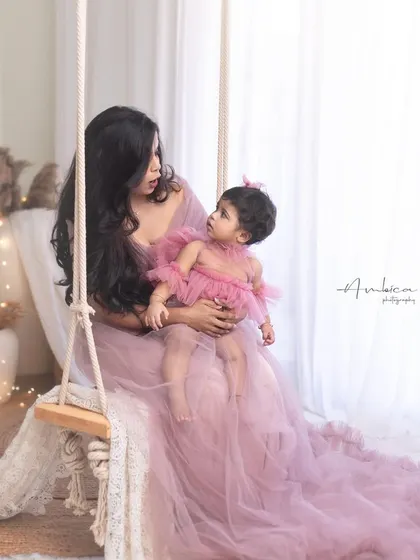 A mother and her one-year-old daughter share a quiet moment on the swing. The matching pink tulle outfits, both from my client wardrobe, add a touch of magic to this birthday portrait.