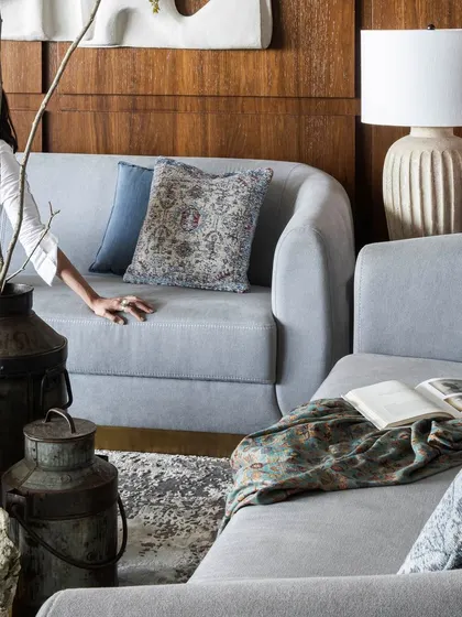 This living room is all about warmth, texture, and subtle elegance. The wooden wall paneling brings a rich, natural backdrop, while the powder blue sofas add a soft, calming contrast, creating a space that feels collected and curated.