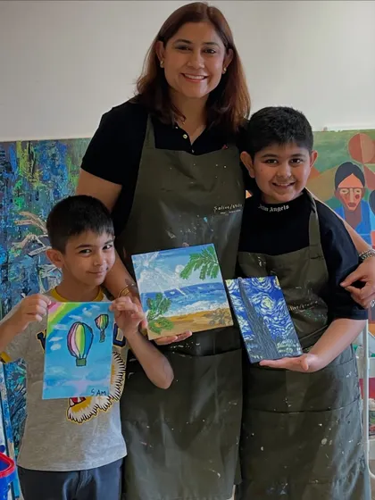 A mother and her two sons with their fantastic paintings. One recreated Van Gogh's 'Starry Night' while the other painted a cheerful hot air balloon scene.