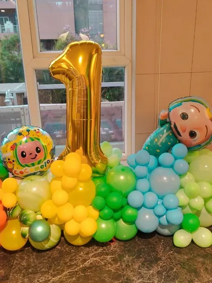 A cute Cocomelon balloon arrangement for a first birthday, perfect as a table centerpiece or a standalone decoration.