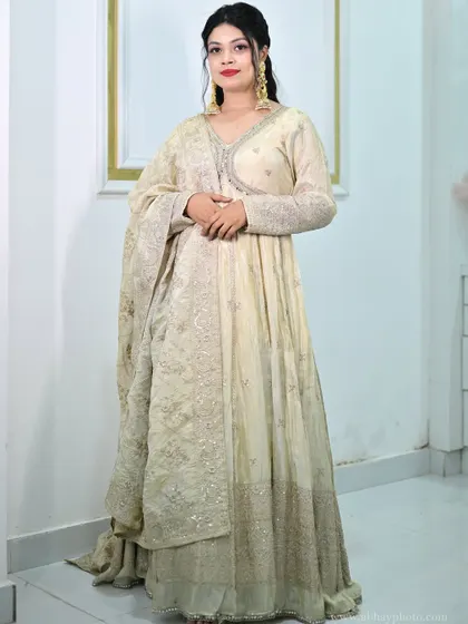 A full-length shot of the ivory anarkali gown, showing its flowing silhouette and the intricate embroidery along the hem.