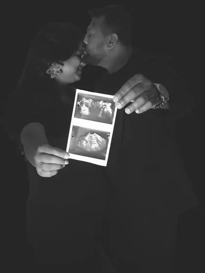 A close-up, artistic black and white photo of a couple holding their ultrasound scan. This silhouette style creates a timeless and emotional memory of the early stages of expecting.