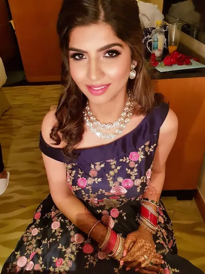 A beautiful portrait of my client in a stunning off-shoulder gown. The makeup is a classic glam look with defined eyes and a bright pink lip.