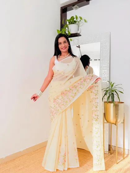 This cream-colored Kota Doria saree with delicate embroidery is the epitome of elegance. It's perfect for a formal event or a daytime party.