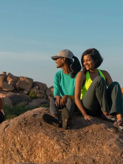 Friends relaxing on a boulder, enjoying the Hampi sunset. These quiet moments of connection are just as memorable as the climbs themselves.