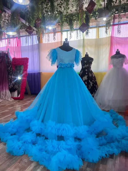 This sky-blue gown with a ruffle trail and floral belt is a beautiful and dreamy addition to our collection.