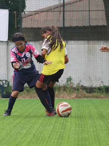 Two players battling for possession during a competitive match. Our training prepares our girls for the physical demands and high stakes of league football.