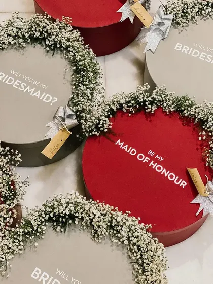 "Will you be my Bridesmaid?" and "Be my Maid of Honour" proposal boxes. These elegant round boxes are decorated with baby's breath for a touch of floral romance.
