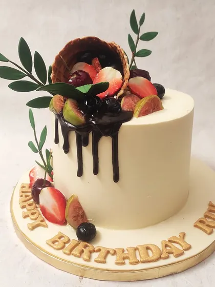 We celebrate nature's sweetness with this fresh fruit cornucopia cake. A waffle cone overflows with fresh strawberries, cherries, and figs, drizzled with rich chocolate, creating a vibrant and delicious design that is both rustic and elegant.