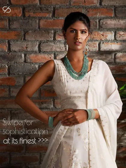 This white lehenga is styled with turquoise beaded jewelry to add a pop of color, demonstrating how accessories can enhance a monochromatic look.