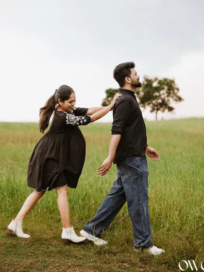 A playful moment where the bride-to-be pushes her partner forward, capturing their fun-loving relationship.
