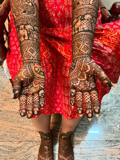 Full coverage bridal mehendi for hands and feet. The design is dense with traditional patterns, including elephants, lotuses, and intricate checkerboard fills.