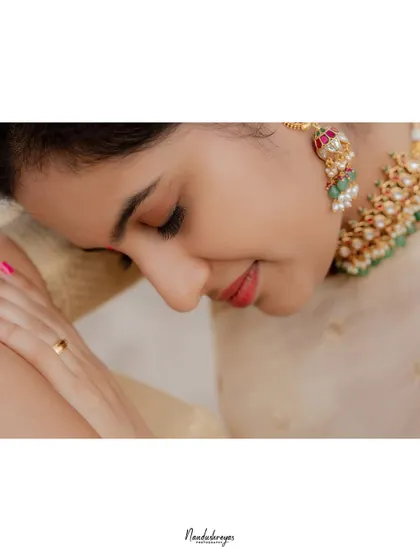 A delicate close-up of the bride-to-be, highlighting her serene expression and beautiful traditional jewelry.