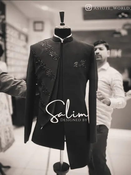 A black Indo-Western jacket with an asymmetrical drape and subtle black-on-black embroidery. The focus here is on the unique cut and understated texture.