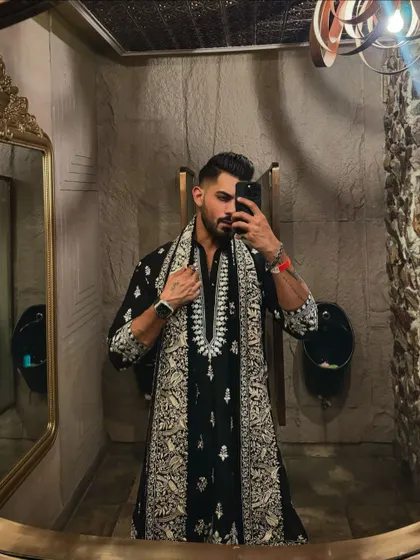 A mirror selfie capturing the details of the black kurta and shawl. Even in a casual shot, the quality of the embroidery and the fit of the garment is apparent.