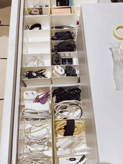 A drawer full of neatly organized cables and chargers. This is just one example of the detailed organizing we do to bring order to every corner of a home.