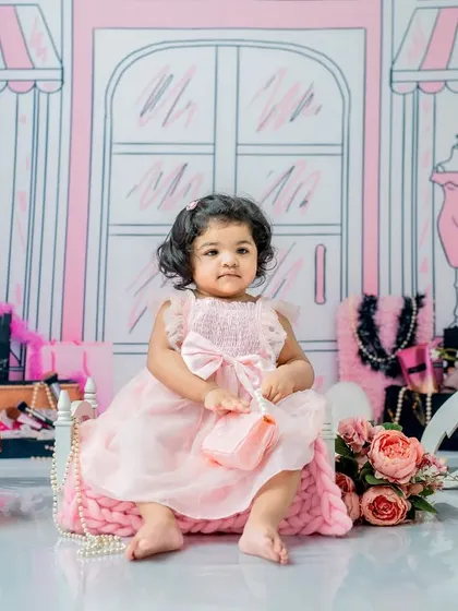 A different take on the Barbie theme, with a softer pink dress and props. This portrait captures a sweet, poised moment before the cake smash fun begins.