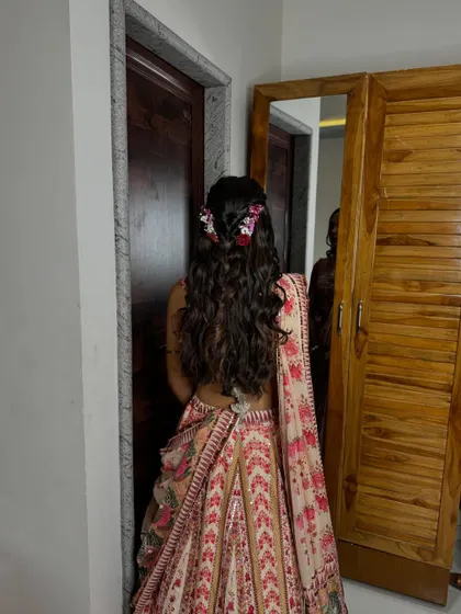 A full view of the back, showing how the floral hairstyle complements her flowery lehenga.