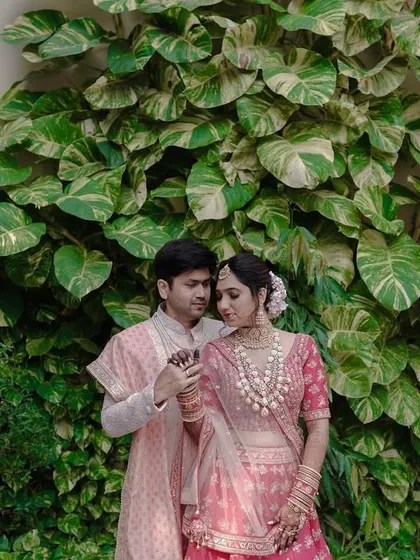 A sweet and gentle portrait against a wall of lush greenery. The couple's soft expressions and the vibrant natural background create a fresh and romantic image.