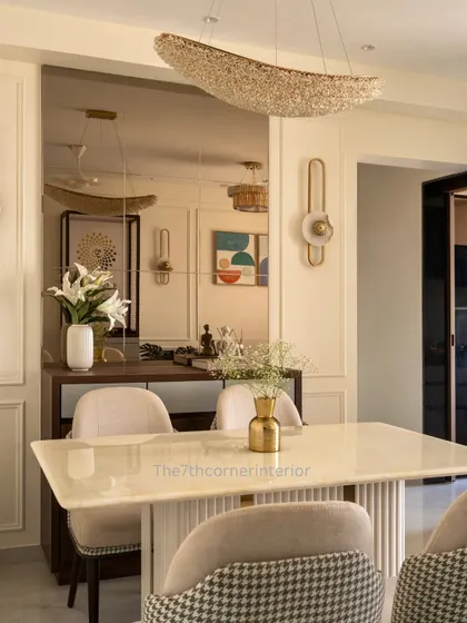 Another perspective of the dining space, highlighting the reflection in the tinted mirror wall, which adds depth and sophistication. The statement crystal chandelier casts a warm, inviting glow.