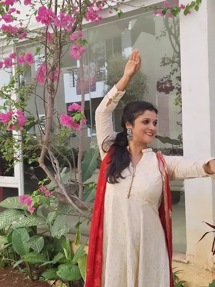 A full shot of the dance pose against a backdrop of beautiful pink flowers.
