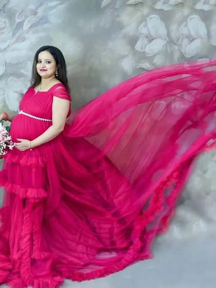 A dynamic studio shot with a flowing pink gown against a floral backdrop.