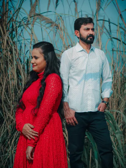 A stylish pose from a pre-wedding shoot in a field of tall grass, capturing a cool, confident vibe.